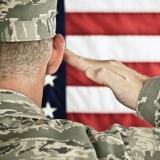 Military soldier saluting American flag